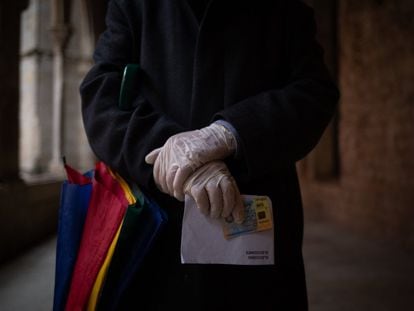Una persona se dirige a votar con el sobre y su DNI en las elecciones al Parlamento de Cataluña en febrero de 2021.