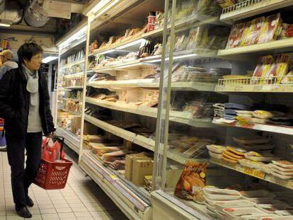 Un cliente observa las estanterías de un supermercado.