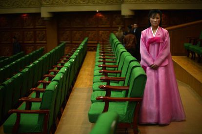 Una mujer, vestida con el traje tradicional norcoreano, espera para colocar en sus asientos a los asistentes al Festival de Primavera de Artes.