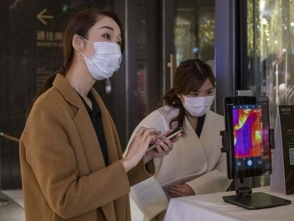 Dos mujeres con máscaras en Shangai (China).