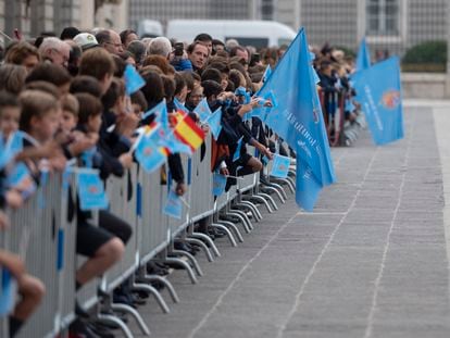 Un grupo numeroso de personas aguarda al paso de la comitiva junto al Palacio Real, este martes en Madrid.