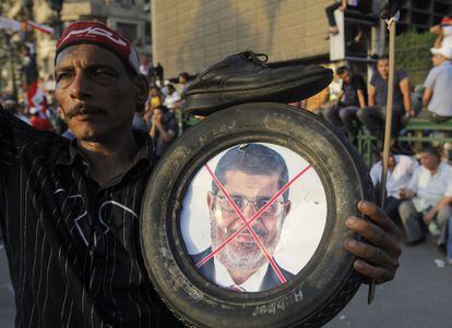 Un hombre egipcio lleva un zapato sobre la foto de Morsi s&iacute;mbolo de rechazo en los pa&iacute;ses musulmanes. 