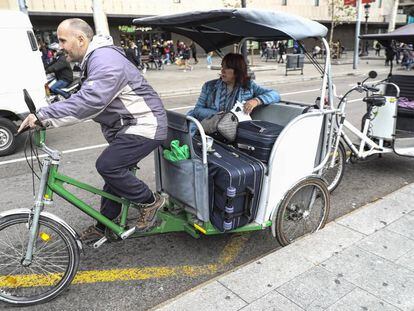 Un bicitaxi en plaza de Catalu&ntilde;a con una turista y sus maletas.