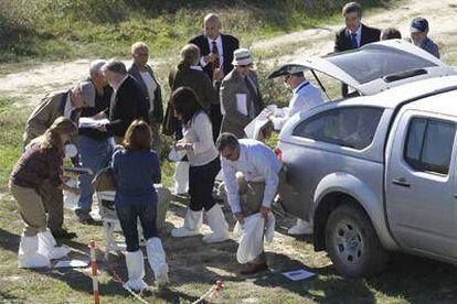 Miembros de la delegación de EE UU y del Ciemat español se calzan protectores durante su visita a terrenos contaminados en Palomares.