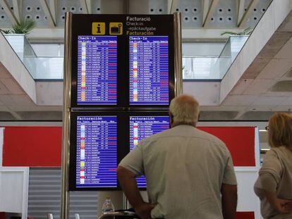 Pasajeros consultando vuelos en el aeropuerto de Palma de Mallorca.