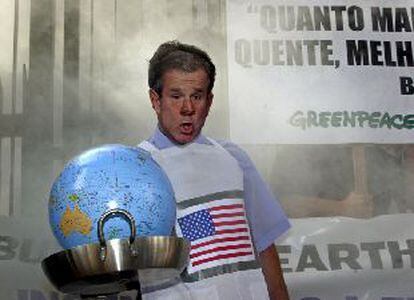 Un militante de Greenpeace con una careta de Bush y un globo terráqueo en una sartén, ayer en Sâo Paulo.