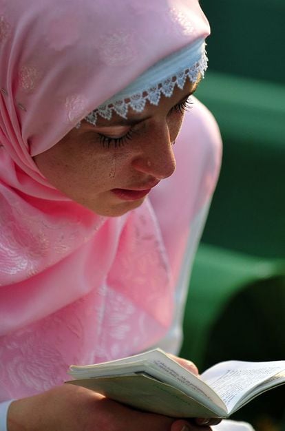 Una mujer superviviente de la matanza de Srebrenica, llora junto a uno de los féretros en el cementerio memorial de Potocari, 10 de julio de 2013. Durante la ceremonia, se leyeron los nombres de las 409 víctimas sepultadas, entre ellos 44 niños y un anciano que tenía 76 años.