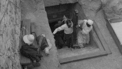 Carter y un trabajador egipcio sacan un trozo de un lecho de la tumba de Tutankamón en febrero de 1923 mientras los retrata otro miembro del equipo, probablemente Lord Carnarvon.