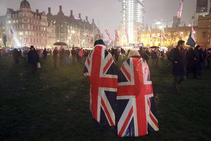 Dos personas llevan la bandera del Reino Unido a sus espaldas, celebrando la salida de la Unión Europea, en Londres. 