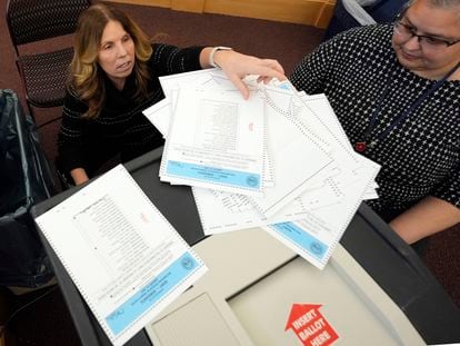 Trabajadoras electorales prueban la máquina de recuento de papeletas para las primarias de Nuevo Hampshire en el Centro Municipal de Derry.