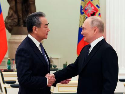 El presidente ruso, Vladímir Putin, y el jefe de Exteriores chino, Wang Yi, estrechan las manos en su encuentro en Moscú este miércoles