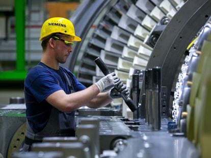 Un trabajador ajusta componentes de una turbina, en una fábrica de Siemens en Berlín en 2016.