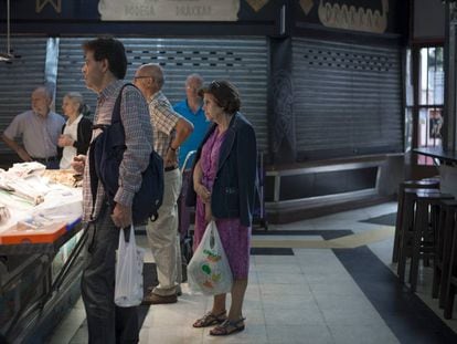 Varias personas compran en un mercado de Madrid.