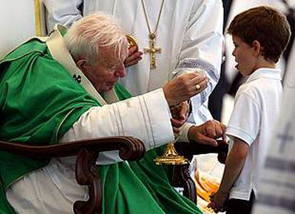 El Papa da la comunión a un niño en Toronto.