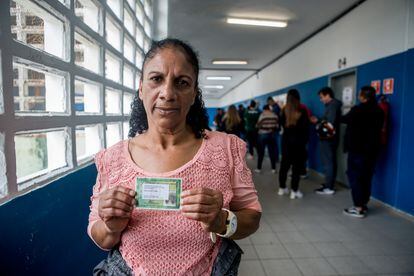 La votante Edna Soares muestra su comprobante de voto.