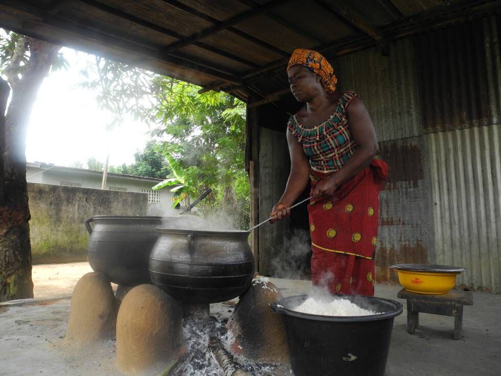 Una mujer cocina en cacerolas en el centro escolar de N'Zikro, en Costa de Marfil.
