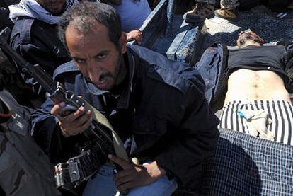 El cuerpo de un soldado de las tropas del líder libio, Muamar el Gadafi, es transportado por los rebeldes libios en una furgoneta en Ajdabiya (Libia), el 10 de abril de 2011.