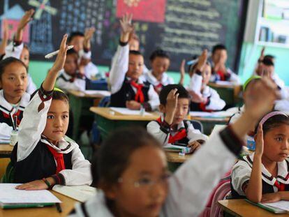 Los estudiantes de una clase de lengua tibetana levantan la mano para responder una pregunta en el colegio experimental de educación primaria de Lhasa, capital de la región autónoma de Tíbet, en junio de 2009.