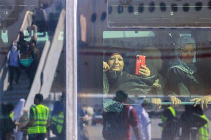 Un grupo de palestinos evacuados de la franja de Gaza esperaban en el interior de un autobús tras aterrizar en el aeropuerto de Abu Dabi este lunes, como parte de una misión humanitaria organizada por Emiratos Árabes Unidos.