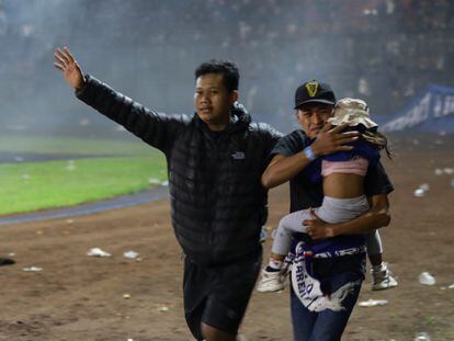 Malang (Indonesia), 01/10/2022.- Soccer fans evacuate a girl during a clash between fans at Kanjuruhan Stadium in Malang, East Java, Indonesia 02 October 2022. At least 127 people including police officers were killed mostly in stampedes after a clash between fans of two Indonesian soccer teams, according to the police. EFE/EPA/H. PRABOWO
