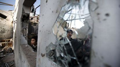 J&oacute;venes palestinos contemplan los da&ntilde;os sufridos por un edificio en Gaza por los ataques israel&iacute;es de la noche pasada. 