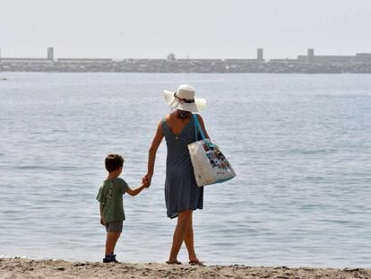 Una mujer y un niño pasean por la playa de El Zapillo en Almería. 