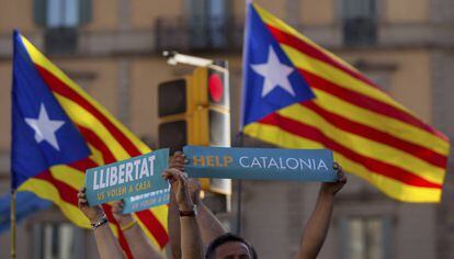 Dos personas lenvantan sus pancartas en la manifestaci&oacute;n convocada por la Mesa por la Democracia en Barcelona.