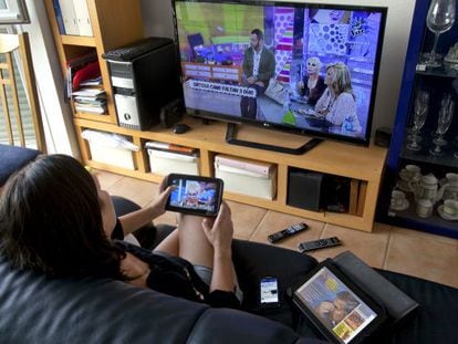 Ver la televisión y enviar mensajes con la tableta o el móvil es un hábito en los hogares.