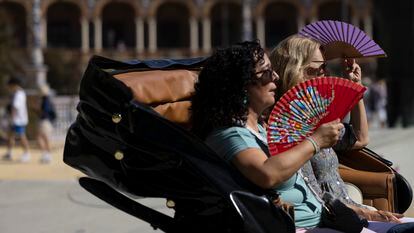 Dos turistas se abanican en una calesa, este jueves en Sevilla, donde se rozaron ya los 37 grados.