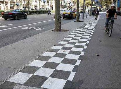 Señales horizontales en blanco y negro para indicar precaución en los carriles bici próximos a las paradas de autobuses en la Gran Via.