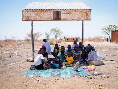 Un grupo de sursudaneses descansa a la sombra de una parada de autobús improvisada en Renk, Sudán del Sur, el 17 de mayo de 2023.
