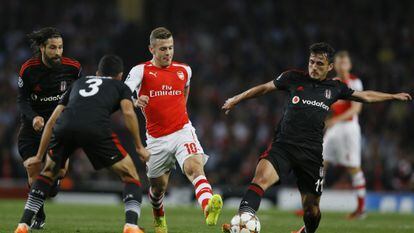 Wilshere protege el balón ante tres rivales.