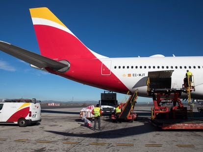 Personal de tierra de Iberia carga un Airbus330-200 con destino Bolivia en el aeropuerto de Barajas, en 2022.