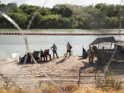 Migrantes esperan ser transportados por autoridades estadounidenses luego de cruzar el río Bravo, en Eagle Pass (Texas), el 24 de julio.