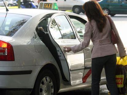 Una clienta sube a un taxi en Madrid. 