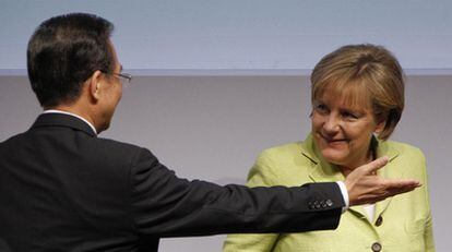 El primer ministro  chino, Wen Jiabao, junto a la canciller alemana, Angela Merkel, en un foro económico celebrado ayer en Berlín.