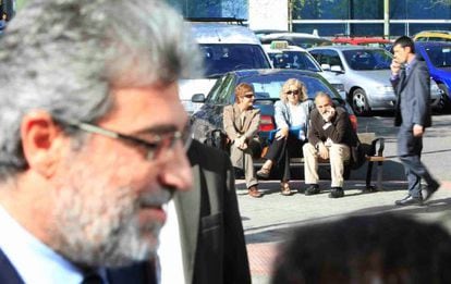 Miguel &Aacute;ngel Rodr&iacute;guez camina cerca de la Audiencia de Madrid ante la mirada de Luis Montes, sentado en un banco, el pasado abril.