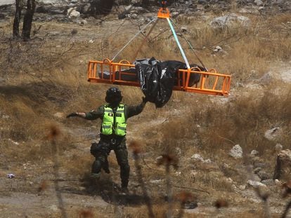 Rescatistas y forenses elevan los cuerpos que estaban al fondo de la barranca usando un helicóptero, el 31 de mayo en Zapopan (Estado de Jalisco).