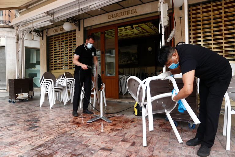 Dos empleados de una cafetería de Málaga preparan el lunes la terraza para poder abrir al público.