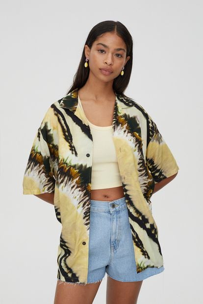 Si quieres algo más veraniego para poder lucir en el chiringuito durante tus vacaciones, atenta a esta camisa estampada, estilo hawaiana y silueta oversize de Pull & Bear. Su precio rebajado es de 9,99€.