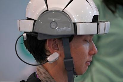 A CES visitor is trying out the iSync Wave EEG headset, which scans and analyzes brain waves using AI-based software, and claims it can detect neurological problems.