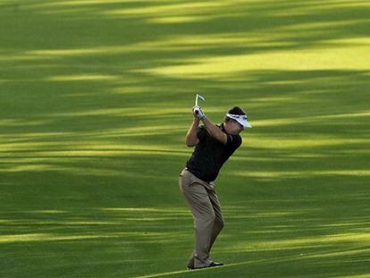 El golfista estadounidense Kenny Perry hace el swing con un hierro en la aproximación al hoyo 13, el sábado.