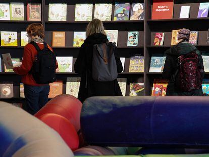 Varias personas consultan libros en los expositores del pabellón español de la Feria del Libro de Fráncfort.