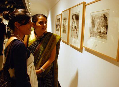 Dos mujeres contemplan uno de los grabados de la 'Suite Vollard' de Picasso expuestos en la primera sede de la institución en India
