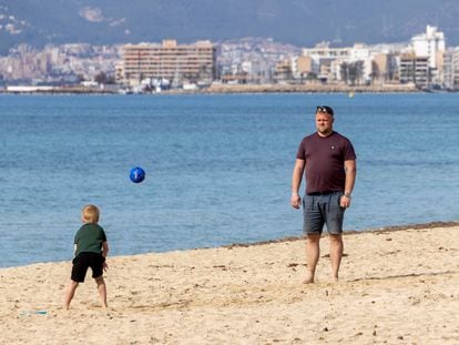 Un hombre juega con su hijo este viernes en la playa de La Palma.