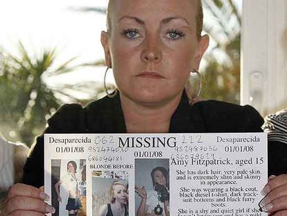 La madre de Amy Fitzpatrick muestra un cartel para su búsqueda.