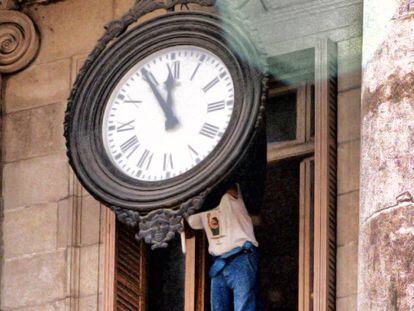 Un operario cambia la hora de un reloj del Ayuntamiento  de Barcelona.