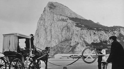Tráfico en la carretera que lleva de España a Gibraltar, esperando en la barrera a que aterrice un avión, en una imagen de la primera mitad del siglo XX.