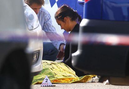 Una mujer llora ante el cuerpo cubierto del hombre muerto en Figueres.