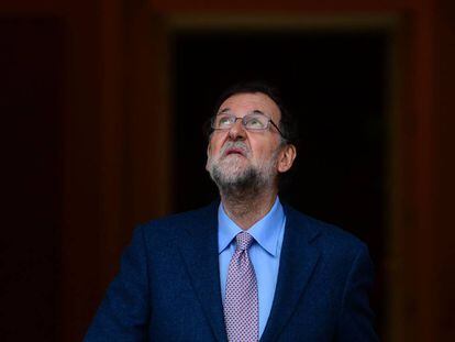 Mariano Rajoy mira al cielo, antes de la llegada del presidente de Ecuador, Rafael Correa.